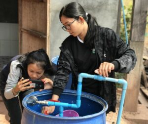 Chanrika (left) and Mariny (right) from the EWB Australia in Cambodia team assess water pressure 