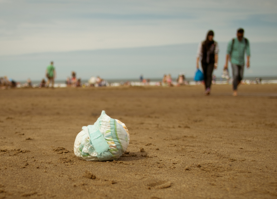 A dispobale nappy discarded on a beach